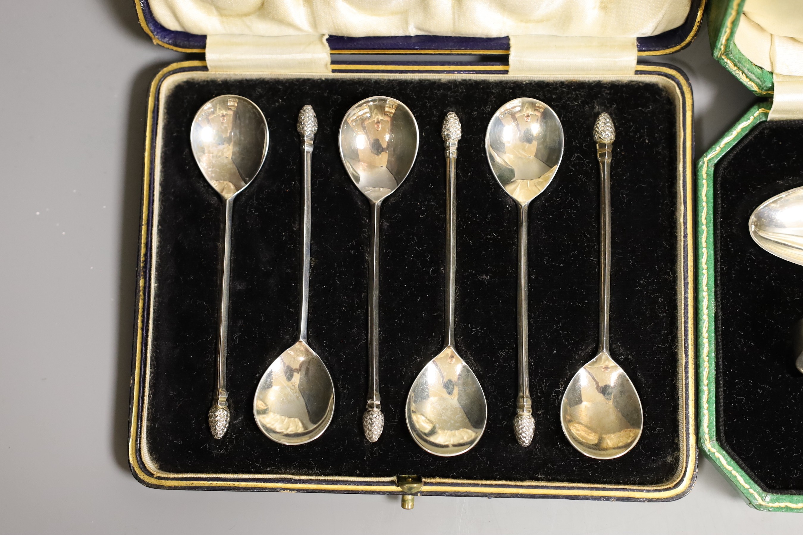 Two cased silver Christening sets, egg cup and spoon and pusher and spoon, a cased set of acanthus terminal coffee spoons, and a cased set of six apostle teaspoons and tongs, 7oz.
